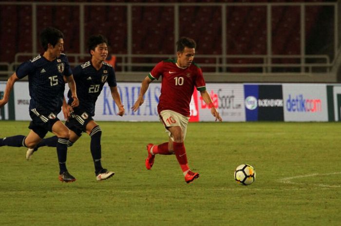   Pemain timnas u-19 Indonesia, Egy Maulana Vikri, melewati dua pemain timnas u-19 Jepang di Stadion Utama GBK, Minggu (25/3/2018).  