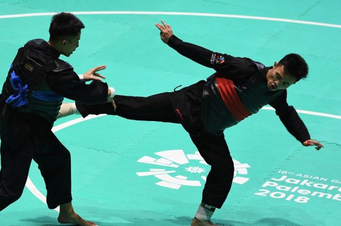 Pesilat Indonesia, Abdul Malik (kanan), saat bertanding melawan pesilat Vietnam, Dinh Tuan Nguyen, dalam babak 16 besar Kelas B Putra Asian Games 2018 di Padepokan Pencak Silat Taman Mini Indonesia Indah (TMII), Jakarta, Kamis (23/8/2018). Abdul Malik akhirnya sukses meraih emas.