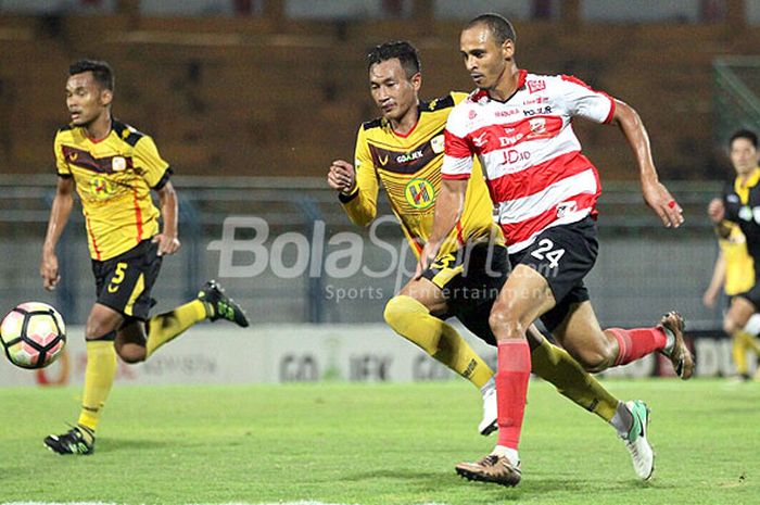 Striker Madura United, Peter Odemwingie (kanan), berupaya lepas dari dua pengawalan Barito Putera, Febri Setiadi Hamzah (kiri) dan Wahyudi Setiawan, dalam laga pekan ke-33 Liga 1 di Stadion Gelora Bangkalan, Bangkalan, Minggu (5/1/2017).