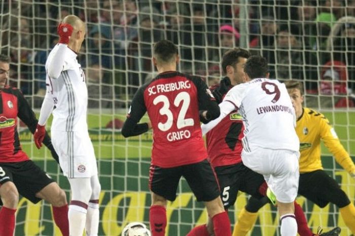 Penyerang Bayern, Robert Lewandowski (no. punggung 9), melepas tembakan ke gawang Freiburg saat kedua tim bersua pada lanjutan Bundesliga di Stadion MAGE SOLAR, Freiburg, Jumat (20/1/2017) waktu setempat.