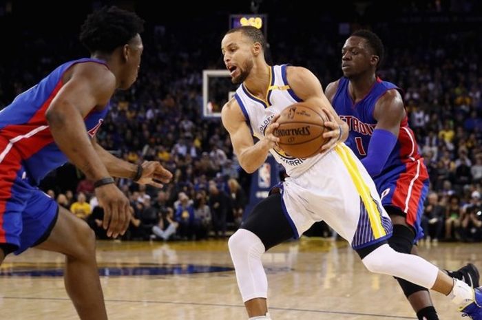 Bintang Golden State Warriors, Stephen Curry (jersey putih, #30), mendribel bola seraya dijaga dua pemain Detroit Pistons, Stanley Johnson (kiri, #7) dan Reggie Jackson (#1), saat menjalani laga musim reguler NBA di Oracle Arena, Oakland, California, Amerika Serikat, Kamis (12/1/2017) malam waktu setempat atau Jumat pagi WIB.