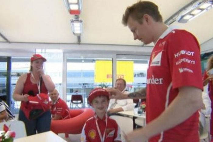 Pebalap Ferrari dari Finlandia, Kimi Raikkonen, memberi topi miliknya kepada fan ciliknya, Thomas, setelah balapan GP Spanyol 2017 yang berlangsung di Circuit de Barcelona-Catalunya, 14 Mei lalu.