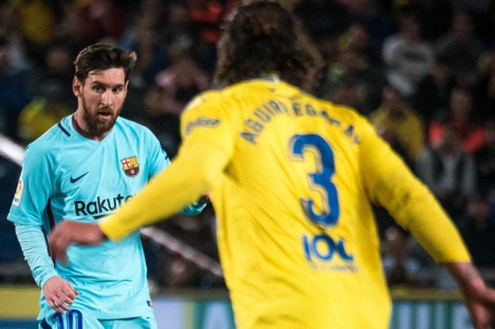Bek Las Palmas, Matias Aguirregaray, mencoba menghadang striker Barcelona, Lionel Messi, saat kedua tim bertemu di pekan ke-26 Liga Spanyol yang berlangsung di Stadion Gran Canaria, pada Jumat (2/3/2018).