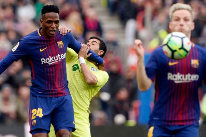 Yerry Mina menahan gerak Angel Rodriguez dalam mengejar bola saat Barcelona menjamu Getafe di Camp Nou, Minggu (11/2/2018). 