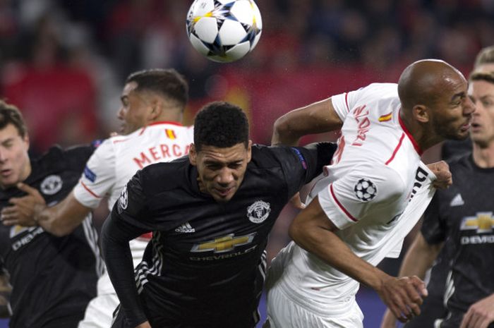 Aksi bek Manchester United, Chris Smalling (tengah), saat berduel dengan gelandang Sevilla, Steven N'Zonzi (kedua dari kanan), dalam  laga leg 1 babak 16 besar Liga Champions 2017-2018 di Stadion Ramon Sanchez Pizjuan, Sevilla, Spanyol, pada Rabu (21/2/2018).