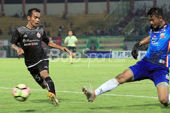 Pemain sayap Persija, Riko Simanjuntak (kiri), berupaya merebut bola dari penguasaan kiper Madura United, Satria Tama, dalam ajang Suramadu Super Cup 2018 di Stadion Gelora Bangkalan, Jawa Timur, Senin (08/01/2018) malam.