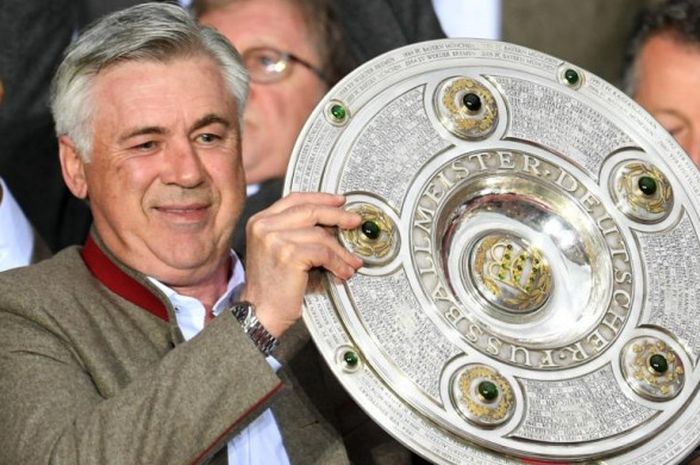 Carlo Ancelotti berpose dengan trofi juara Liga Jerman 2016-2017 untuk Bayern Muenchen di Balai Kota Muenchen setelah timnya mengalahkan Freiburg, 20 Mei 2017.