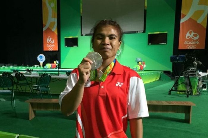 Lifter Indonesia, Sri Wahyuni, memamerkan medali perak Olimpiade Rio 2016 yang didapat saat turun pada nomor 48 kg di Rio Centro, Rio de Janeiro, Sabtu (6/8/2016).