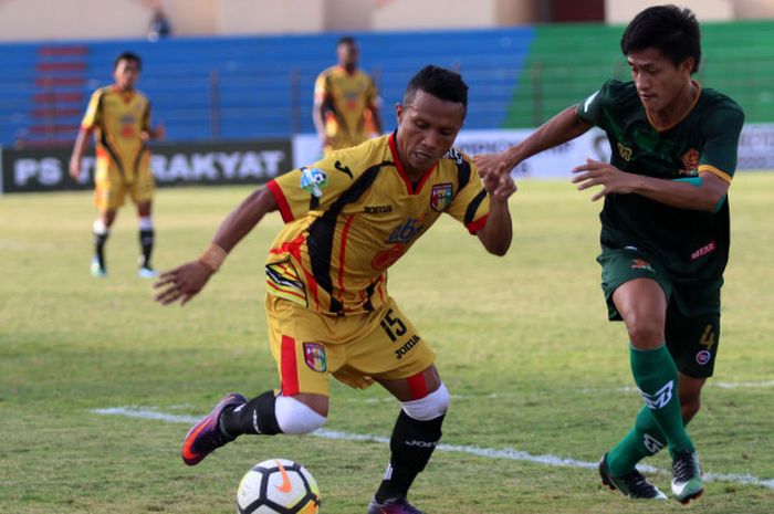Gelandang Mitra Kukar, Hendra Adi Bayaw berusaha melindungi bola dari sergapan pemain PS Tira, Mahdi Fahri Albar (kanan) pada laga pekan ke-15 Liga 1 2018 di Stadion Sultan Agung, Kabupaten Bantul, 10 Juli 2018. 
