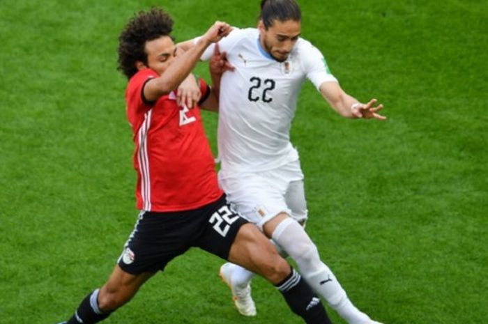 Amr Warda mencoba merebut bola yang dalam penguasaan Martin Caceres pada laga Mesir vs Uruguay di Ye