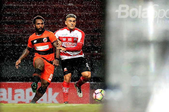 Striker Madura United, Cristian Gonzales (kanan), berebut bola dengan pemain Perseru Serui, Nerius Alom, pada hari pertama laga kedua Piala Presiden 2018 Grup C di Stadion Gelora Bung Tomo Surabaya, Jawa Timur, Kamis (18/01/2018) malam.