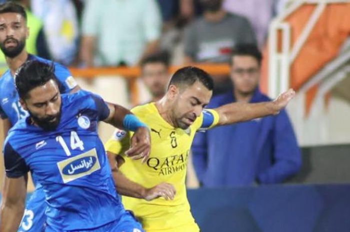 Gelandang Al Sadd, Xavi Hernandez (kanan) duel dengan pemain Esteghlal, Farshid Bagheri pada laga leg pertama perempat final regional barat Liga Champions Asia 2018 di Stadion Azadi, Teheran, 27 Agustus 2018. 