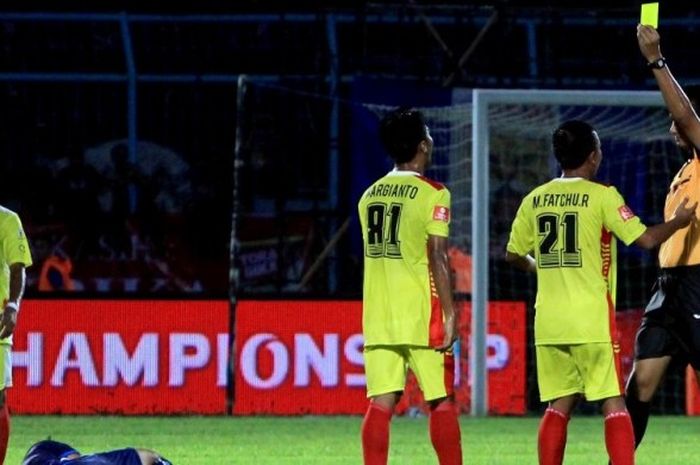 Wasit Toriq Al Katiri memberikan kartu kuning pada pemain Bhayangkara Surabaya United dalam lanjutan Torabika Soccer Championship melawan tuan rumah Arema Cronus yang berakhir dengan skor 3-0 di Stadion Kanjuruhan Malang, Jawa Timur (15/05/2016). 