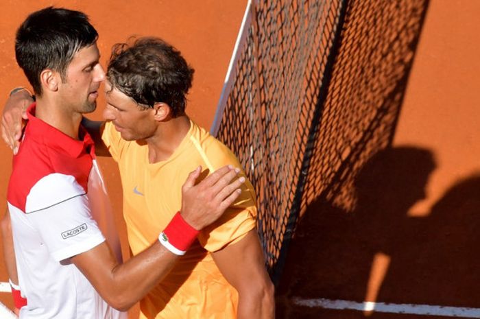  Petenis tunggal putra Spanyol, Rafael Nadal, berpelukan dengan Novak Djokovic (Serbia) seusai memenangi laga semifinal turnamen Italian Open di Foro Italico, Roma, Sabtu (19/5/2018). 