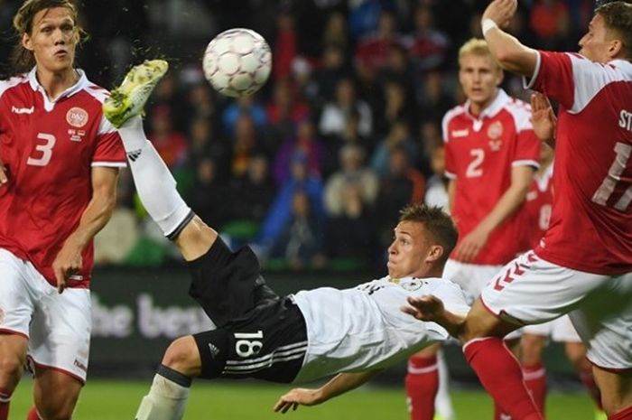 Bek Timnas Jerman, Joshua Kimmich, melakukan tendangan salto untuk mencetak gol ke gawang Jerman dalam pertandingan persahabatan di Brondby, Denmark, 6 Juni 2017. Tampak pemain Denmark, Jannik Vestergaard (kiri) dan Jens Stryger Larsen (kanan), berusaha menghalanginya. Duel berakhir imbang 1-1. 