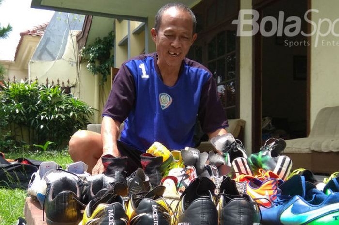 Mustakim, kitman Arema FC sedang menjemur sepatu pemain.