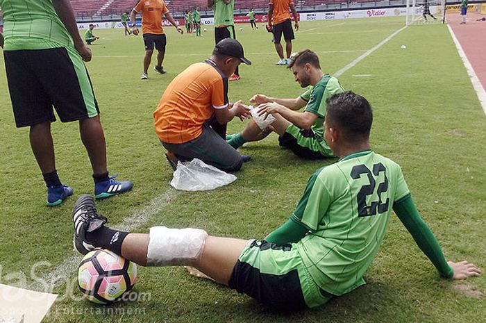 Dua pemain Persebaya Surabaya, Abu Rizal Maulana (22) dan Robertino Pugliara mendapatkan perawatan dari tim medis dan fisioterapi Persebaya Surabaya saat latihan di Gelora Bung Tomo Surabaya, Selasa (27/3/2018).