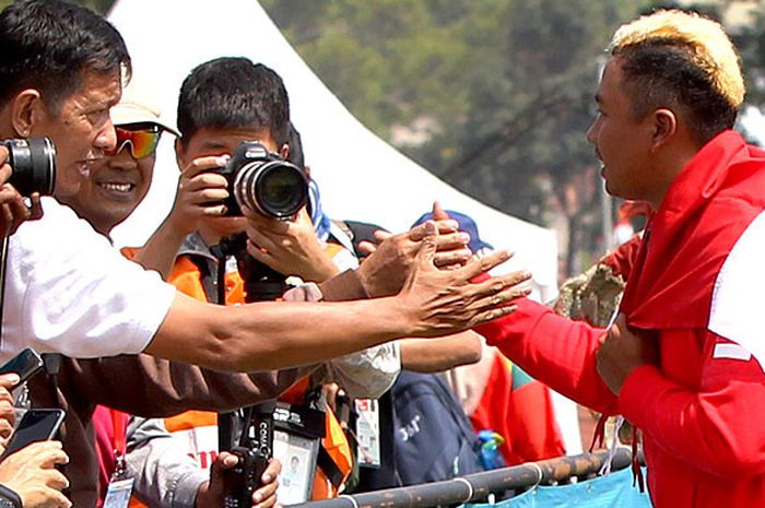 Atlet paralayang putra Indonesia, Jafro Megawanto menyalami pendukungnya setelah dipastikan merebut medali emas untuk katagori perorangan putra nomor ketepatan mendarat, Asian Games 2018 di Cisarua, Puncak, Bogor, Jawa Barat, Kamis (23/8/2018).