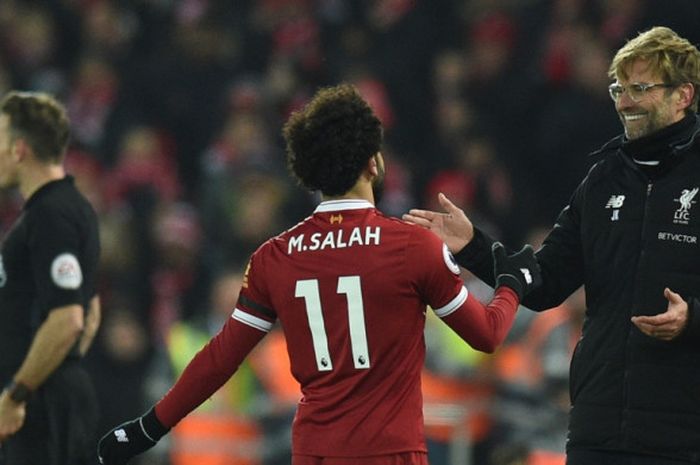 Manajer Liverpool FC, Juergen Klopp (kanan), menyambut Mohamed Salah, yang ditarik keluar lapangan, dalam laga Liga Inggris kontra Manchester City di Stadion Anfield, Liverpool, pada 14 Januari 2018.