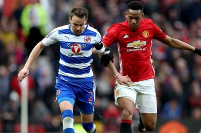 Penyerang Manchester United, Anthony Martial (kanan), beradu dengan pemain Reading, Chris Gunter, dalam duel putaran 3 Piala FA di Old Trafford pada 7 Januari 2017.