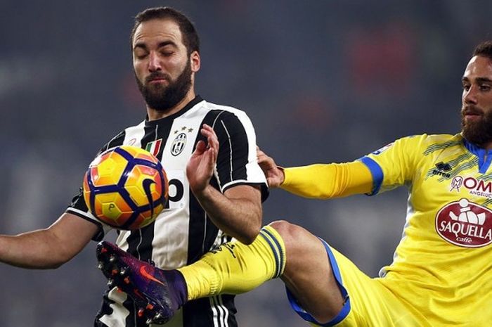 Striker Juventus, Gonzalo Higuian, melawan bek Pescara, Francesco Zampano, pada pertemuan pertama musim ini yang dimenangi oleh Juventus.