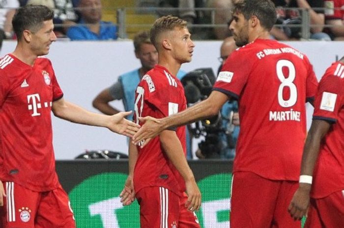 Striker Bayern Muenchen, Robert Lewandowski, mendapat selamat dari Javi Martinez usai mencetak hat-trick ke gawang Eintracht Frankfur di Piala Super Jerman, Commerzbank Arena, Senin (13/8/2018).