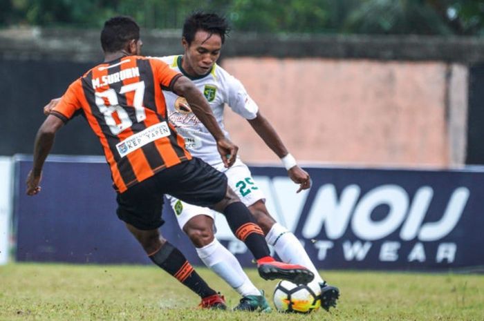 Bek Persebaya, M. Irvan Febrianto (kanan/putih), berhadapan dengan gelandang Perseru, Makarius Fredik Suruan, dalam duel Liga 1 2018 di Stadion Marora, Serui, Selasa (31/7/2018). 