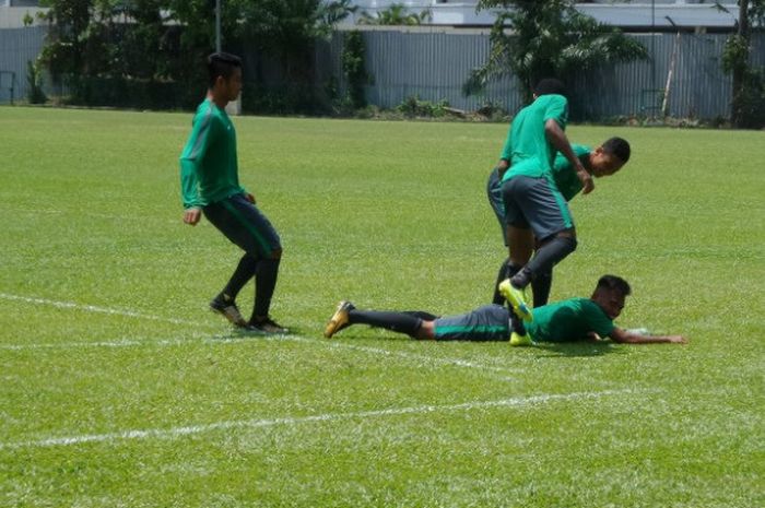 Winger timnas U-22 Indonesia, Sadil Ramdani terjatuh dan 'disambut' teman-temannya seusai latihan sesi siang di lapangan Kelab Aman, Lorong Damai, Kuala Lumpur, Senin (21/8/2017).