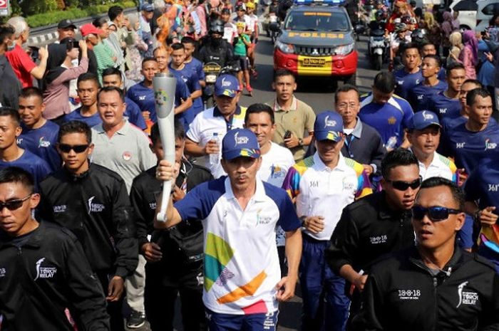 Sekjen Inasgoc Eris Herryanto mengarak obor di Yogyakarta, Kamis (19/7/2018).