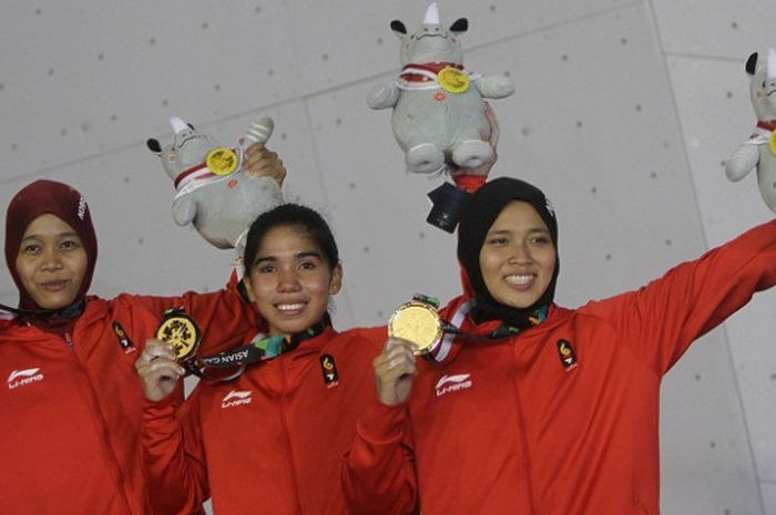 Regu panjat tebing Indonesia Puji Lestari (kiri), Rajiah Sallsabillah (tengah) dan Aries Susanti Rahayu (kanan0 memperlihatkan medali emas setelah menjadi pemenang pada final speed relay putri Asian Games 2018 di Arena Panjat Tebing Jakabaring, Palembang, Sumatera Selatan, Senin (27/8/2018).