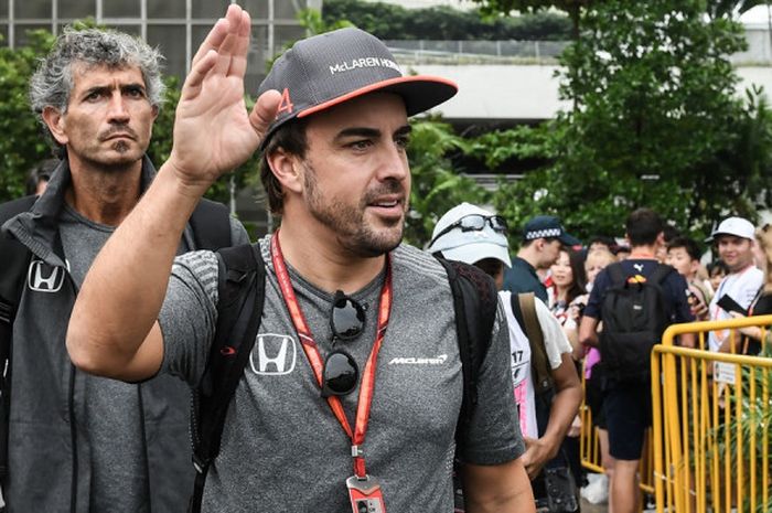 Pebalap McLaren dari Spanyol, Fernando Alonso, melambaikan tangan ke arah penonton saat tiba pada sesi latihan pertama GP Singapura di Sirkuit Jalan Raya Marina Bay, Jumat (15/9/2017).