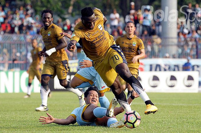Striker Persib Bandung, Ezechiel N'Douassel, berupaya lepas dari hadangan pemain Persela Lamongan, Zainal Haq, dalam laga pekan ke-31 Liga 1 di Stadion Surajaya Malang, Jawa Timur, Minggu (22/10/2017) sore.
