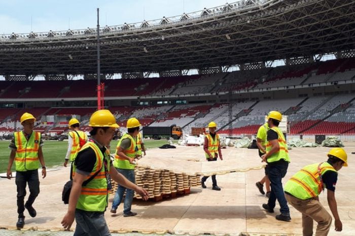 Tim panitia lapangan Asian Para Games 2018 tengah membongkar armor deck di Stadion GBK pada Minggu (7/10/2018)