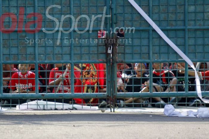 Suporter Persis tak bisa melewati pintu gerbang yang tertutup dan terpaksa menyaksikan pertandingan  Persis Solo vs Sragen United di Liga 2 dari luar Stadion Manahan, Solo, pada MInggu (30/7/2017).
