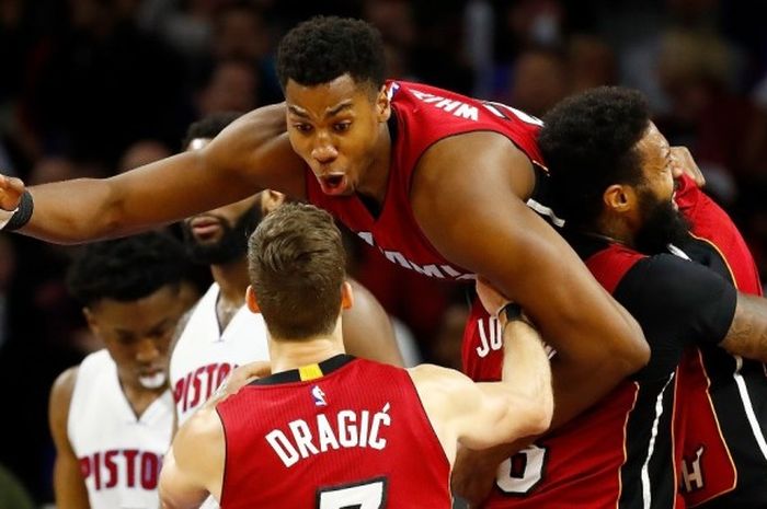 Center Miami Heat, Hassan Whiteside (digendong, #21), melakukan selebrasi bersama rekan-rekan setimnya, James Johnson (#16), dan Goran Dragic (#7), sesaat setelah mengalahkan Detroit Pistons di The Palace of Auburn Hills, Detroit, Selasa (28/3/2017) malam waktu setempat. Heat menang 97-96.