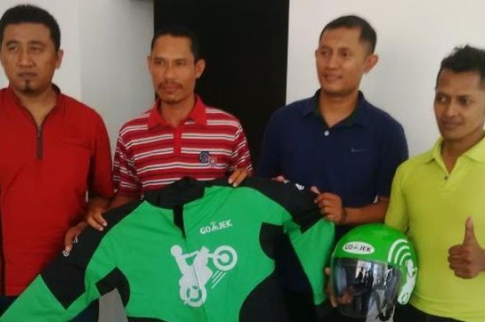 Mantan pemain tim nasional (timnas) Indonesia Anang Ma'ruf (kedua dari kiri) saat menerima atribut Go-Jek setelah resmi bergabung dengan perusahaan aplikasi pemesan layanan ojek itu, Jumat (4/9/2015).