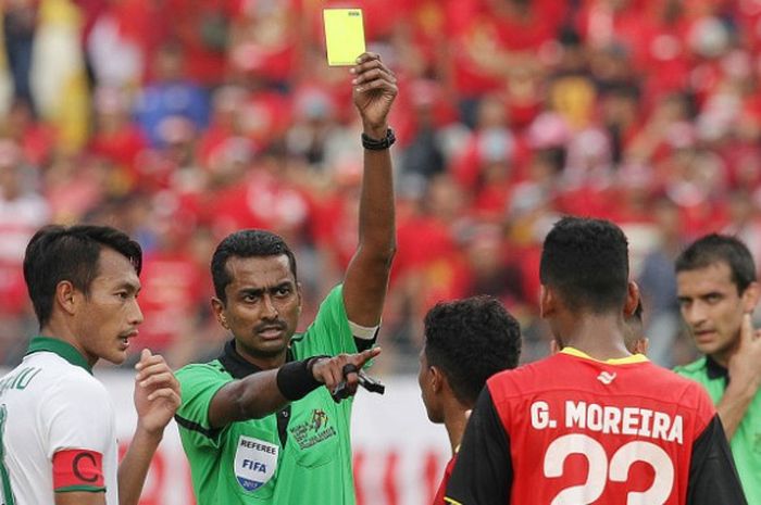 Wasit Nagor Amir memberikan kartu kuning kepada pemain timnas U-22 Timor Leste, Gumario Moreira saat laga kontra Indonesia pada partai ketiga Grup B SEA Games 2017 di Stadion MP Selayang, Selangor, 20 Agustus 2017.  