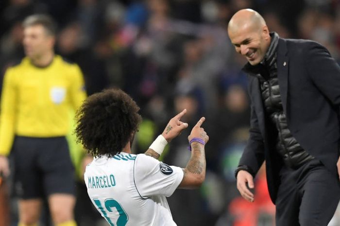 Bek Real Madrid, Marcelo (kiri), merayakan golnya bersama pelatih Zinedine Zidane dalam laga leg pertama babak 16 besar Liga Champions kontra Paris Saint-Germain di Stadion Santiago Bernabeu, Madrid, Spanyol, pada 14 Februari 2018.