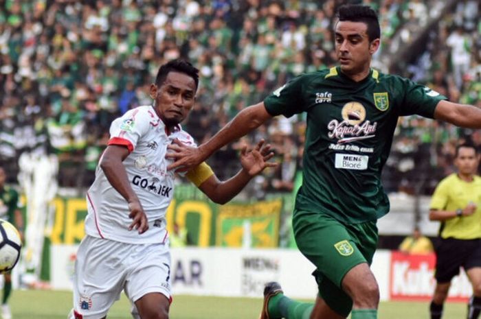 Gelandang Persija Jakarta, Ramdani Lestaluhu dijaga ketat bek Persebaya, Otavio Dutra, di Stadion Gelora Bung Tomo, Surabaya, Minggu (4/11/2018).