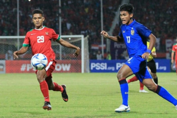   Bek timnas U-19 Indonesia, David Kevin Rumakiek (kiri) mencoba menjauhkan bola dari pemain timnas U-19 Thailand, Kritsana Daokrajai pada laga pamungkas Grup A Piala AFF U-19 2018 di Stadion Gelora Delta, Sidoarjo, 9 Juli 2018.  