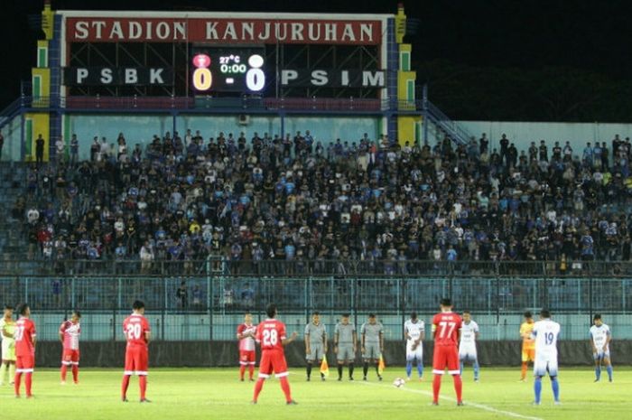Penonton dan pemain serta ofisial laga PSBK Kota Blitar serta PSIM Yogyakarta melakukan hening cipta sebelum memulai laga Grup H play-off Liga 2 musim 2017 di Stadion Kanjuruhan, Kabupaten Malang, Minggu (15/10/2017) malam. 