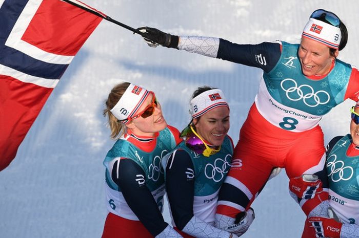 Atlet ski putri Norwegia, Marit Bjoergen, diangkat rekan-rekan senegaranya setelah berhasil memenangi laga final nomor cross country 30 kilometer, Minggu (25/2/2018). Melalui kemenangan Bjoergen, Norwegia keluar sebagai juara umum Olimpiade Musim Dingin Pyeongchang 2018.