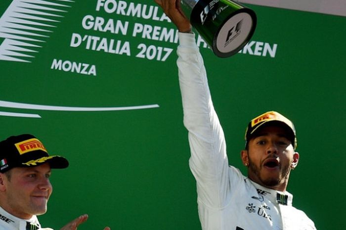 Pebalap tim Mercedes, Lewis Hamilton (kanan), melakukan selebrasi di atas podium setelah memenangi balapan GP Italia yang berlangsung di Autodromo Nazionale, Monza, Minggu (3/9/2017).