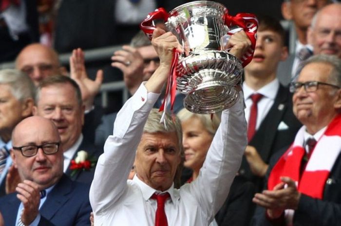 Pelatih Arsenal, Arsene Wenger, mengangkat trofi Piala FA setelah timnya menekuk Chelsea dalam laga final di Stadion Wembley, London, 27 Mei 2017.