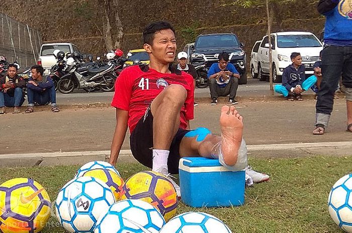 Gelandang Arema FC, Dendi Santoso meringis kesakitan akibat cedera saat latihan di Lapangan Universitas Muhammadiyah Malang pada Selasa sore (31/7/2018).