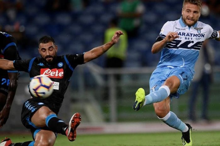 Striker Lazio Ciro Immobile (kanan) mengecoh para pemain bertahan Napoli untuk melepaskan tembakan yang berbuah gol dalam laga Liga Italia di Stadion Olimpico Roma, 18 Agustus 2018.