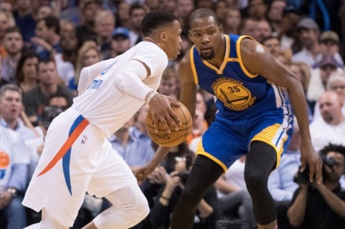 Pemain bintang Oklahoma City Thunder, Russell Westbrook (jersey putih), berupaya melewati penjagaan pemain Golden State Warriors yang juga mantan tandemnya di Thunder, Kevin Durant, pada laga musim reguler NBA di Chesapeake Energy Arena, Oklahoma City, Oklahoma, Amerika Serikat, Sabtu (11/2/2017) malam waktu setempat atau Minggu pagi WIB. Thunder kalah 114-130.