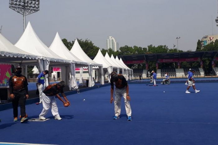 Skuat Lawn Bowls Malaysia (seragam hitam-jingga) bersama Hong Kong (seragam biru) saat menjalani sesi latihan bersama di lapangan hoki GBK, Jakarta, pada Jumat (5/10/2018).