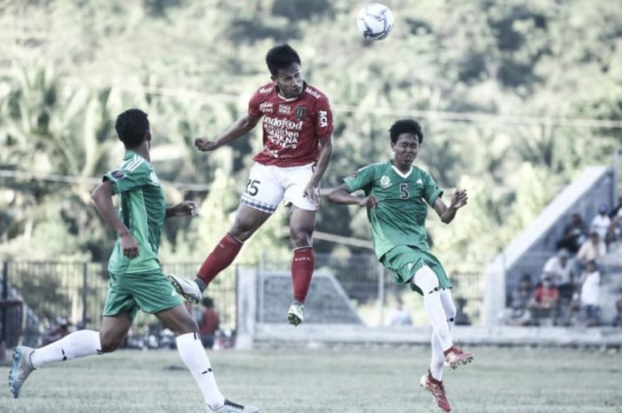 Striker Bali United, Yandi Sofyan, melompat untuk berduel udara dengan dua pemain PS Sumbawa Barat, pada laga Piala Indonesia 2018 yang berlangsung di Stadion Lalu Magaparang, Sumbawa Barat-NTB, Senin (2/7/2018)