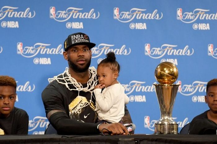 Pebasket Cleveland Cavaliers, LeBron James, menghadiri konferensi pers bersama ketiga anaknya, LeBron Jr (kiri), Zhuri (digendong), dan Bryce (kanan), seusai mengalahkan Golden State Warriors 93-89 pada gim ketujuh final NBA. Kemenangan itu memastikan Cavaliers menjadi Juara NBA 2016 di Oracle Arena, Oakland, California, 19 Juni 2016.